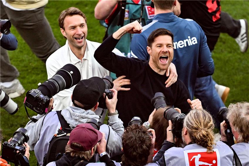 Leverkusens Trainer Xabi Alonso (r) und Sportchef Simon Rolfes jubeln über den Gewinn der Deutschen Meisterschaft. Foto: David Inderlied/dpa