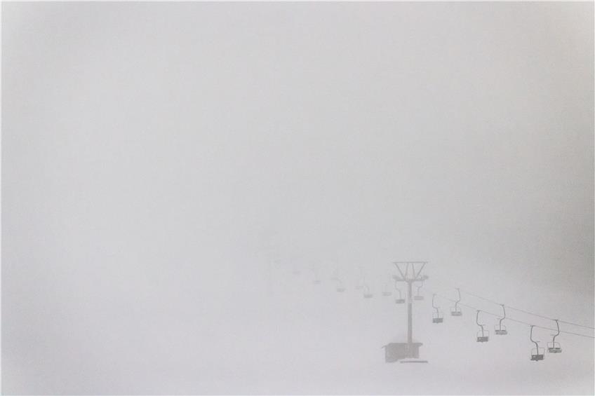 Liftsessel und Liftmasten stehen nahe der Talstation der Feldbergbahn im Nebel. Bild: Philipp von Ditfurth/dpa