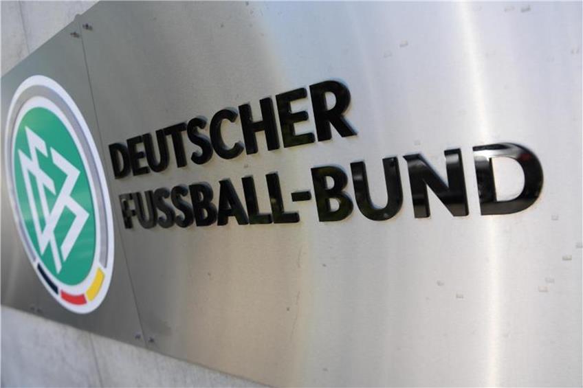 Logo und Schriftzug sind vor der Zentrale des Deutschen Fußball-Bundes (DFB) an einer Mauer platziert. Foto: Arne Dedert/Archiv dpa