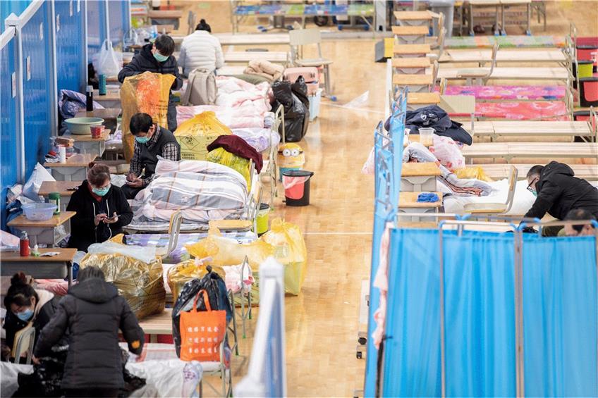 März 2020: Patienten packen neben ihren Betten im provisorischen Krankenhaus von Wuhan ihre Habseligkeiten zusammen. Der autoritäre Staat erzielt beim Kampf gegen die Pandemie schnelle Erfolge. Foto: Fei Maohua, dpa
