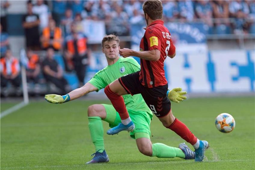 Magdeburgs Torwart Morten Behrens (l.) und Freiburgs Lucas Höler kämpfen um den Ball. Foto: Peter Steffen