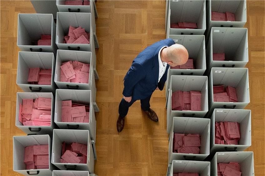 Markus Blocher, Kreiswahlleiter, begutachtet in einer Wahlbehörde zahlreiche mit Stimmzetteln gefüllte Wahlurnen für die Briefwahl. Foto: Sebastian Kahnert/dpa 