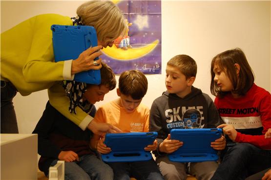 Martina Hanisch weist einige Schüler der Klasse 4b in den Umgang mit dem Spiel auf dem Tablet ein. Bild: Jutta Garber