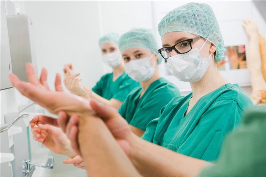 Medizinstudenten vor einem OP-Raum beim Händereinigen. Ob das Examen im April verschoben wird, ist offen. Foto: Julian Stratenschulte/dpa