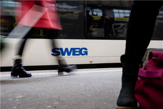 Menschen gehen an einem Zug mit dem Logo der SWEG vorbei. Foto: Ilkay Karakurt/dpa