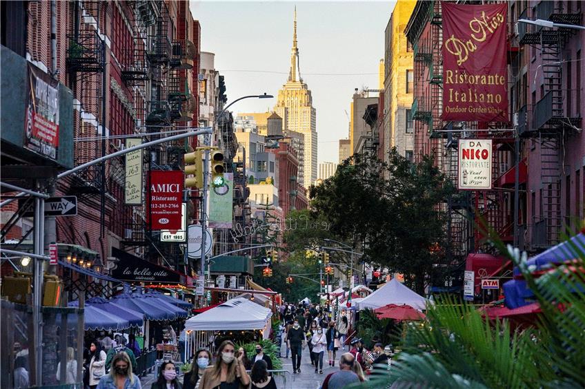 Menschen schlendern durch die Straßen New Yorks. Viele von ihnen sind bereits geimpft. Foto: John Minchillo/AP/dpa