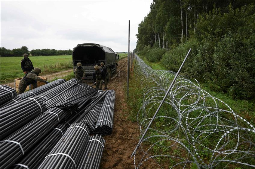 Polnische Soldaten errichten an der Grenze zu Belarus Sperren. Hier kommen immer mehr Migranten an. Foto: Jaap Arriens/afp