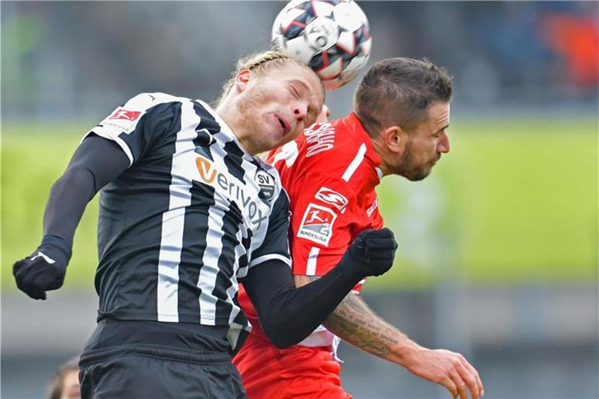 Sandhausens Jesper Verlaat (l) und Regensburgs Marco Grüttner kämpfen um den Ball. Foto: Uwe Anspach dpa/lby