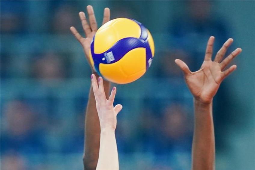 Spielerinnen strecken ihre Arme in Richtung eines Volleyballs. Foto: Uwe Anspach/dpa/Symbolbild
