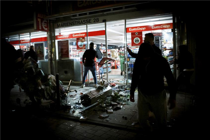 Stuttgart nach der Krawallnacht vom 20. Juni 2020: Menschen vor einem geplünderten Geschäft in der Marienstraße. Foto: Julian Rettig/dpa