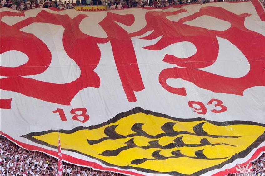 Stuttgarter Fans halten einen Banner mit dem Logo des VfB. Foto: Sebastian Kahnert/dpa/Archivbild