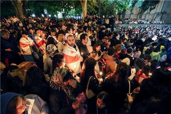 Teilnehmer eines Protestes gegen das "russische Gesetz" in Georgiens Hauptstadt Tiflis, einige in Nationalflaggen gehüllt, versammeln sich in der Dreifaltigkeitskathedrale, um an einem Gottesdienst zur Feier des orthodoxen Osterfestes teilzunehmen.