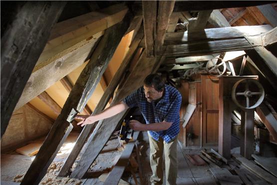 Tilmann Marstaller zeigt auf das älteste Holz im Dachgebälk: einen wiederverwendeten Balken der ursprünglichen Mühle von 1420. Bild: Erich Sommer