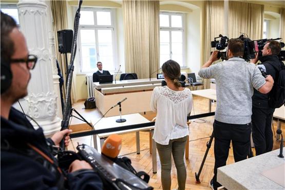Verteidiger Manuel Reiger sitzt hinter der Anklagebank, während Pressevertreter ihn filmen. Foto: Felix Kästle dpa/lsw