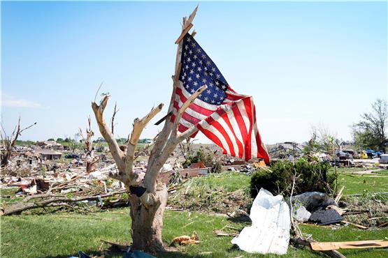 Viele Trümmer und eine einsame Flagge: Greenfield nach dem Tornado. Bild: Charlie Neibergall/dpa