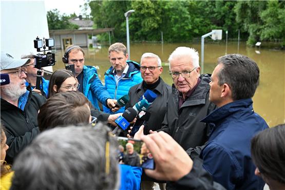 Winfried Kretschmann (Grüne, 2.v,r), Ministerpräsident von Baden-Württemberg, und Landesinnenminister Thomas Strobl (CDU, 3.v.r.) stellen sich nach einer Besichtigung der Hochwasserschäden den Fragen der Journalisten. Foto: dpa