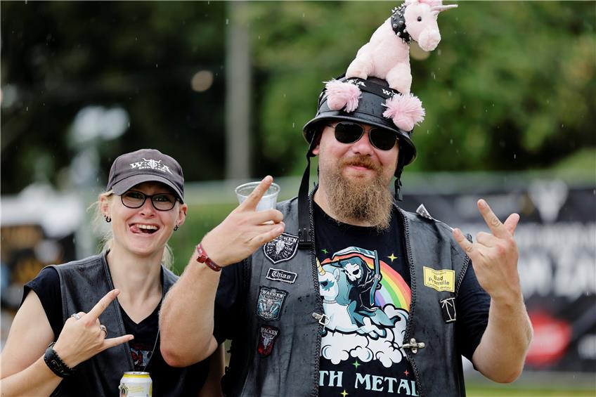 Zwei von zehntausenden Heavy-Metal-Fans, die nach Wacken gereist sind: Magda aus Lübeck und Matthias aus Teterow zeigen den „Pommesgabel“ genannten Metal-Gruß.  Foto: Frank Molter/dpa